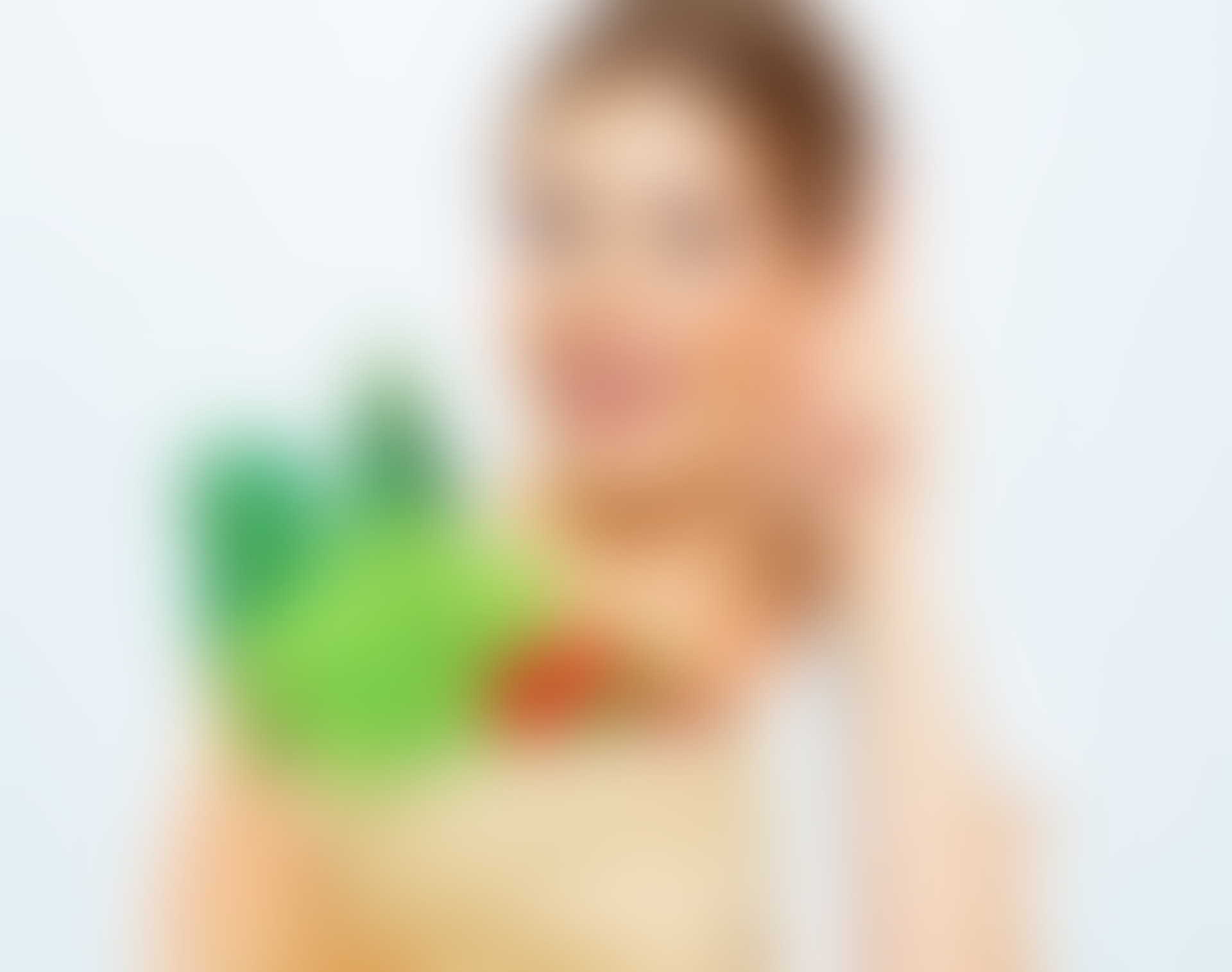 A blurry picture of a woman holding a green object.