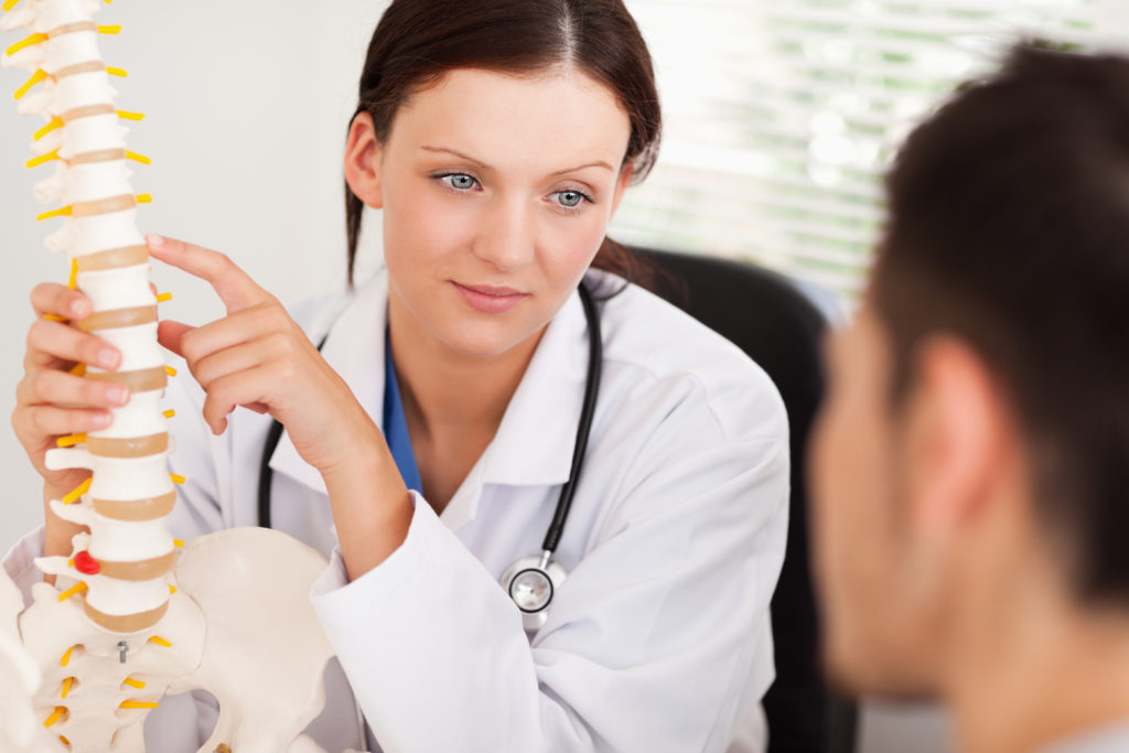 A woman doctor is sitting in front of a man.