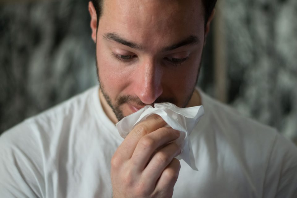 A man with his nose wrapped in a tissue